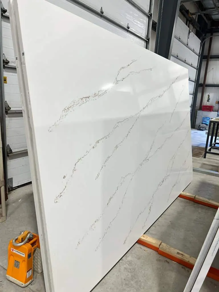 White slab with fine gray veins on a rack inside the shop