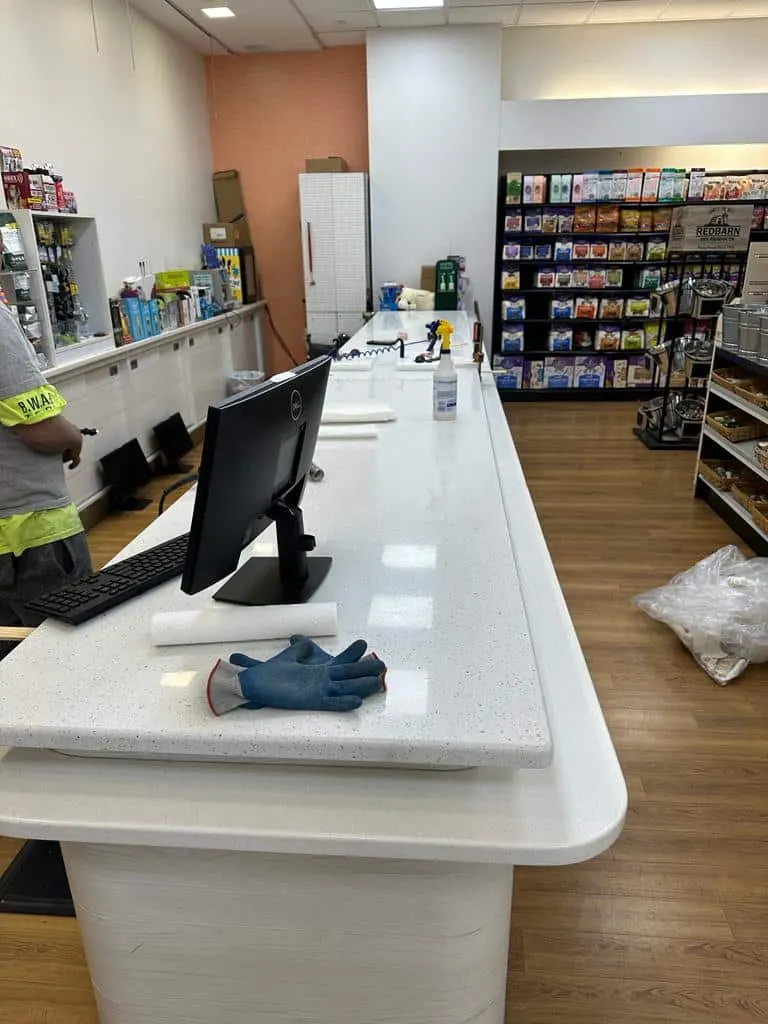 Long checkout counter in a white sparkling quartz with a rounded front, installed in a retail store